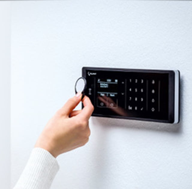 Foto einer Frau die einen RFID-Key an ein Display hält